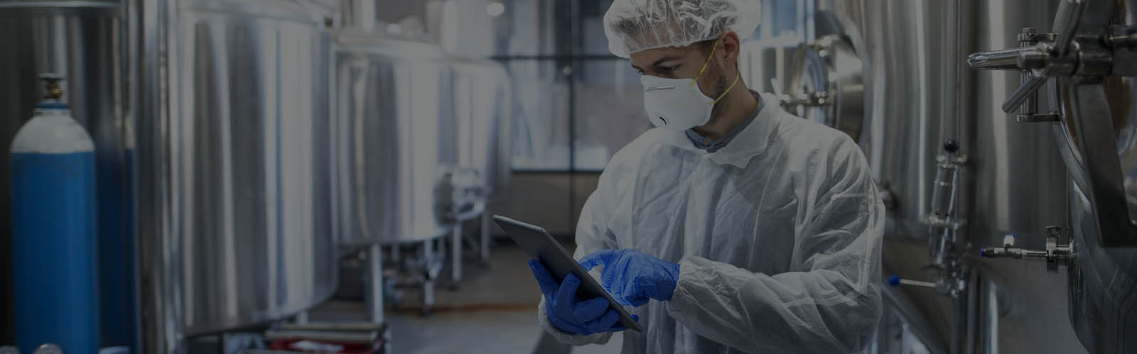 Man looking at tablet in a life sciences manufacturing environment. 