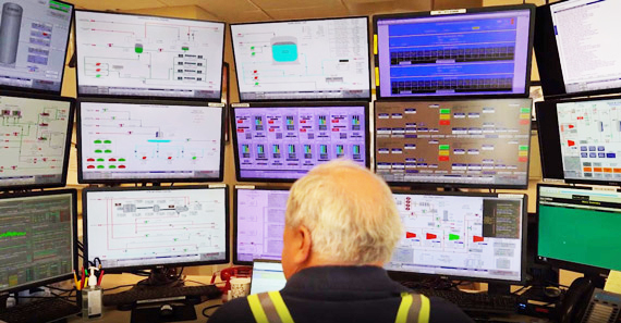technician in front of bank of computer screens showing various measurements, valve repair services