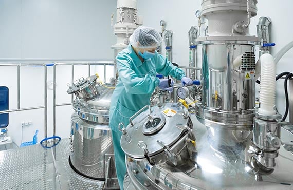 Woman in pharmaceutical manufacturing facility, operations digitalization, automation solutions, automation services